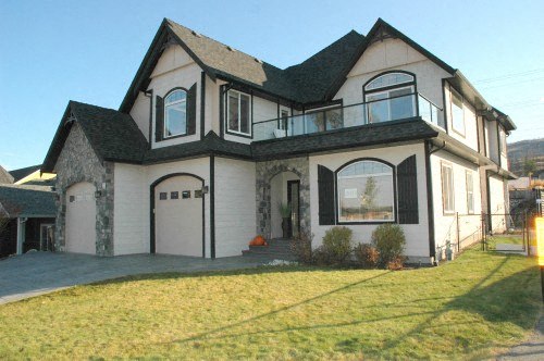A large two-story house with a balcony on the second floor.